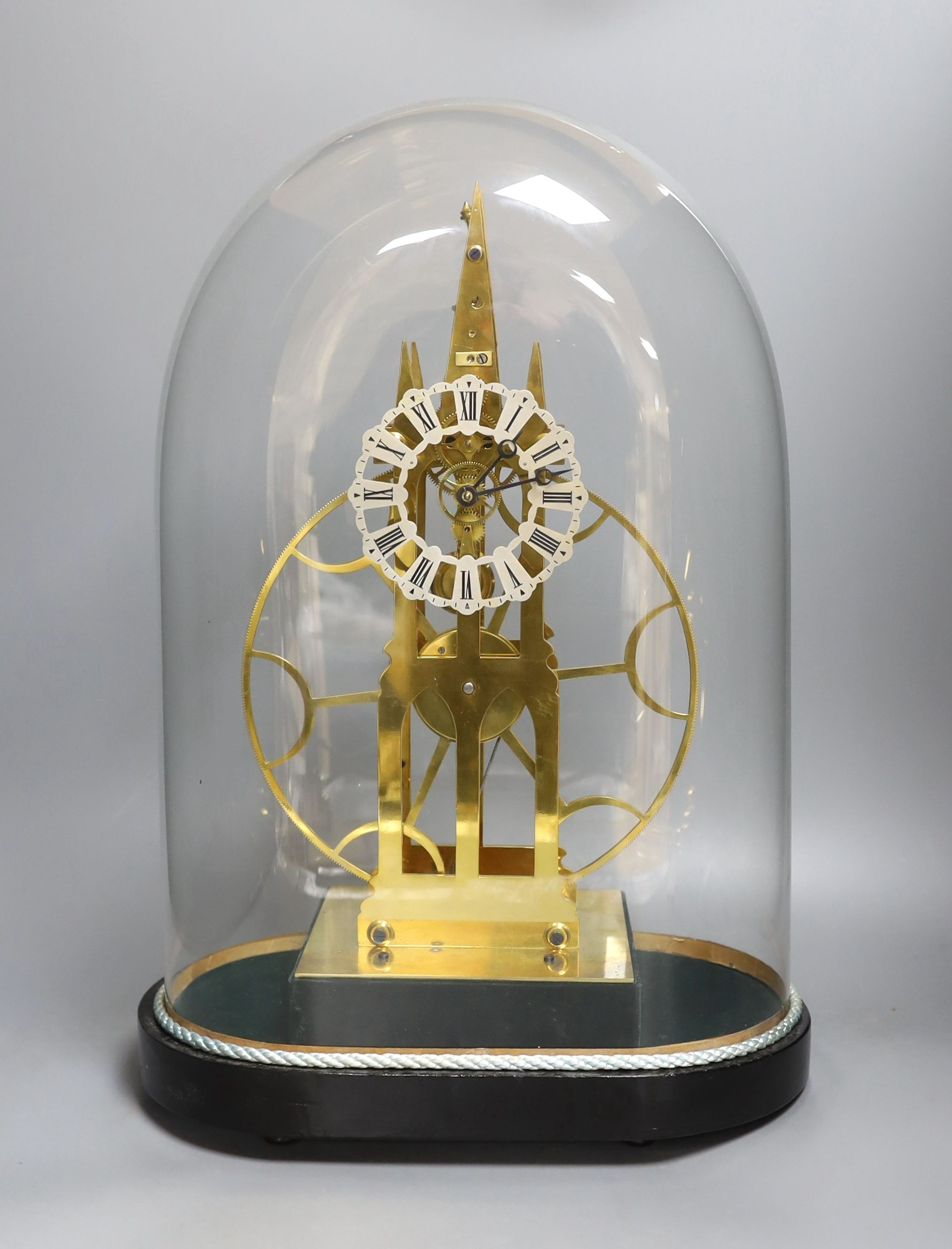 A brass skeleton fusee mantel timepiece, with large wheel, under glass dome on stand, 49cms high.